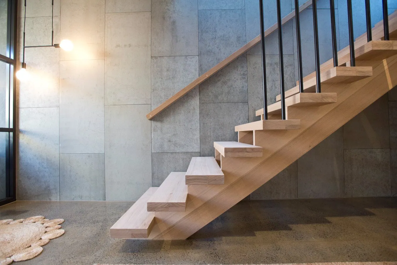 Grind and seal concrete floor beneath a timber floating staircase in a Brisbane home