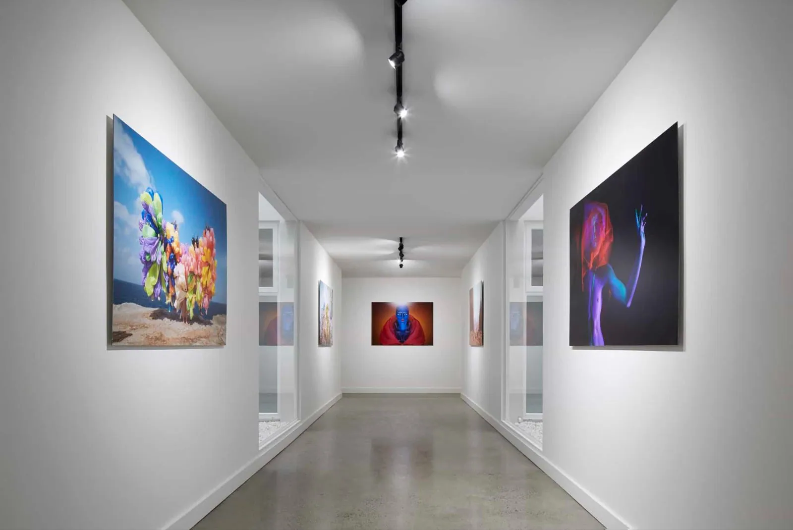 Gallery-style hallway with a pale natural cement-finish concrete floor