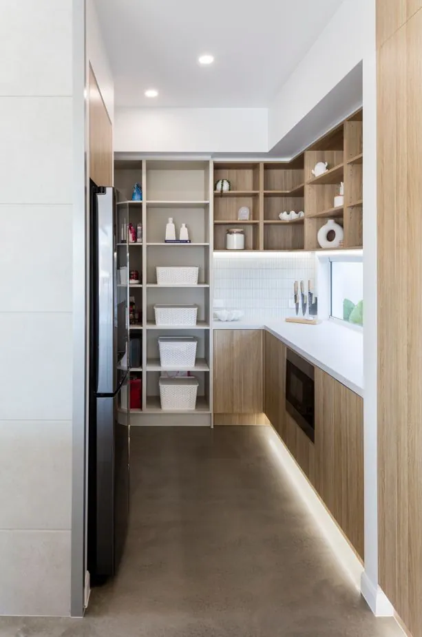 Matte polished concrete floor along the kitchen island and staircase of a Monster Homes residence, Brisbane