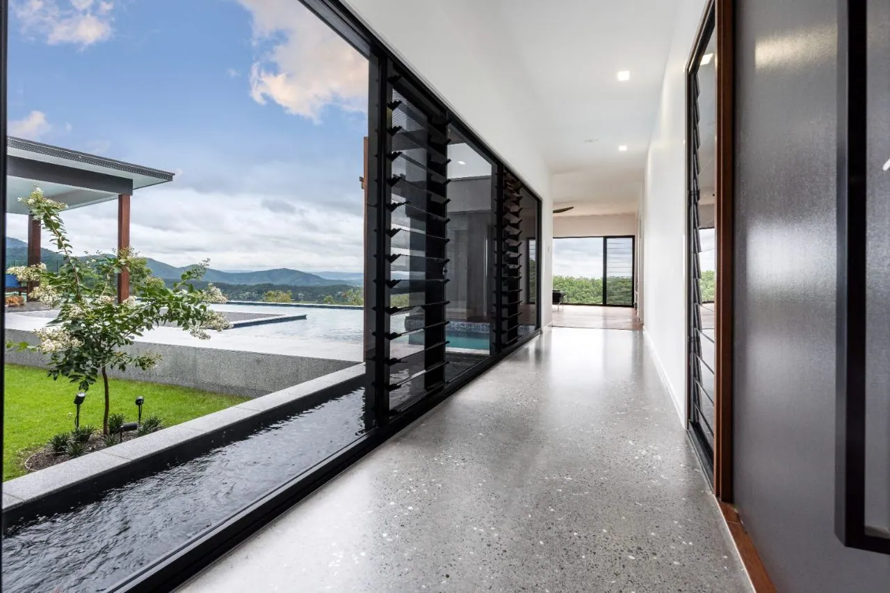 MPC semi-gloss polished concrete along a hallway with infinity pool and mountain view