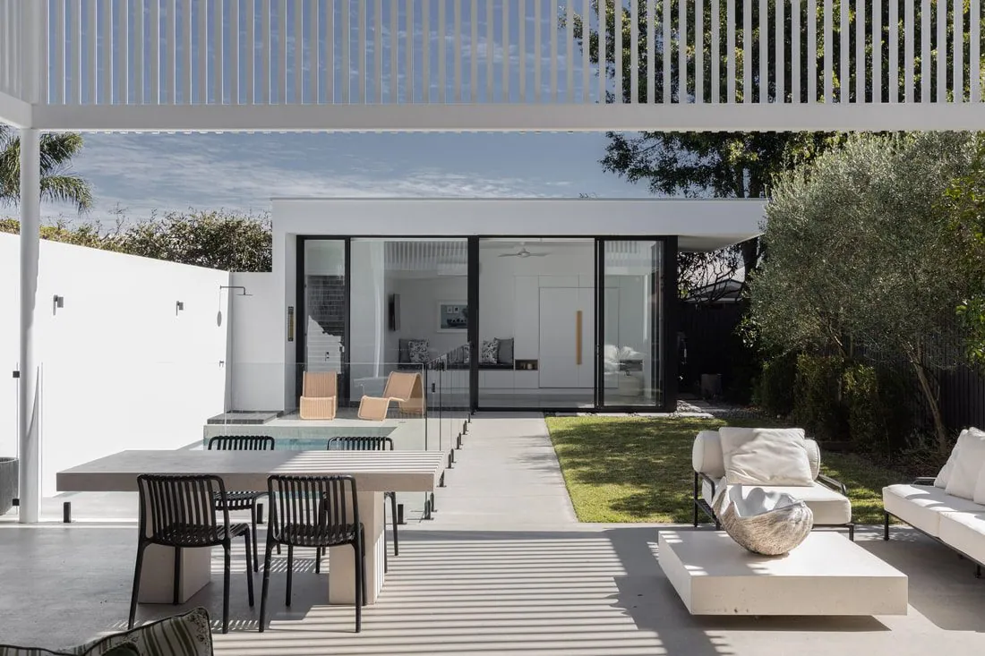 Honed concrete pool surround with outdoor dining and sun loungers at a Brisbane home