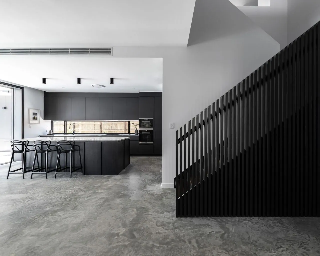 MPC matte polished concrete in a dark kitchen with timber screen