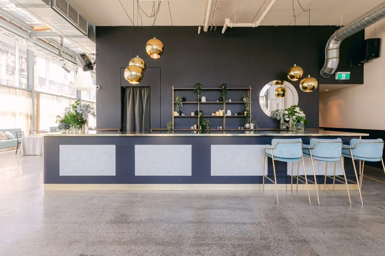 Grind and seal matte-satin concrete in an event space with navy bar