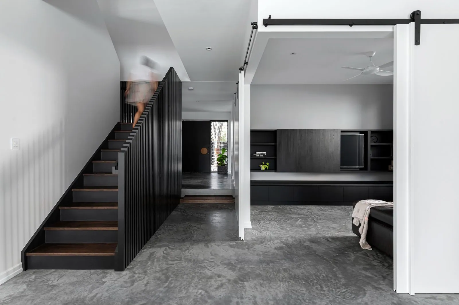Hallway and black steel staircase over a burnished concrete floor