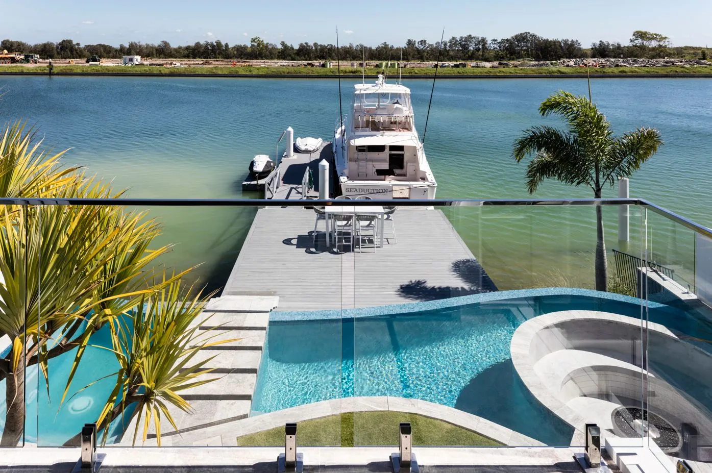 Waterfront pool, jetty and canal outlook from a Monster Homes polished concrete residence, Brisbane