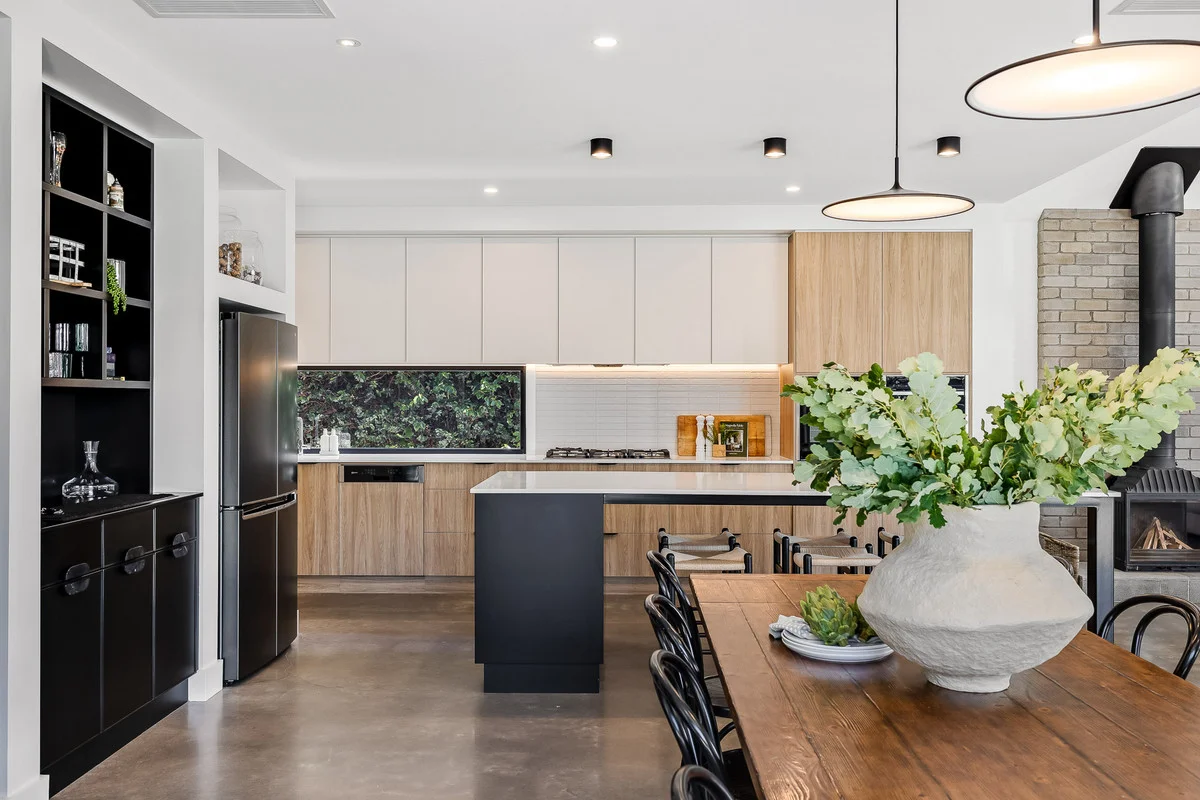 Kitchen and dining with warm timber joinery and a semi-polished concrete floor