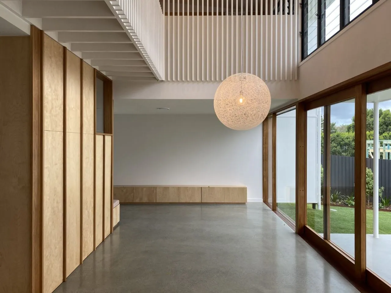 MPC semi-gloss polished concrete in a timber-lined entry with void above