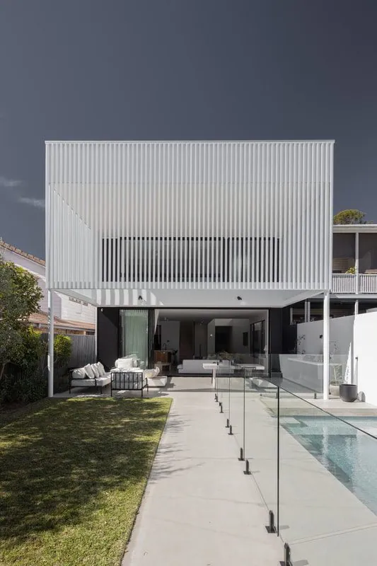 Honed concrete pool surround with glass fencing at a battened modern Brisbane home