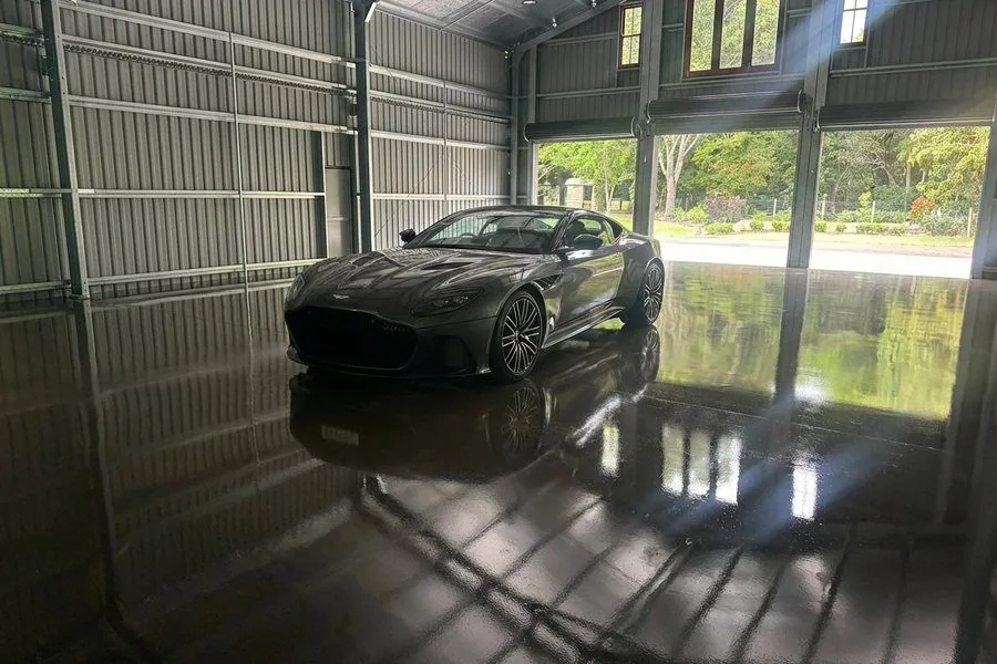 High-gloss grind and seal polished concrete garage floor with a sports car in Brisbane