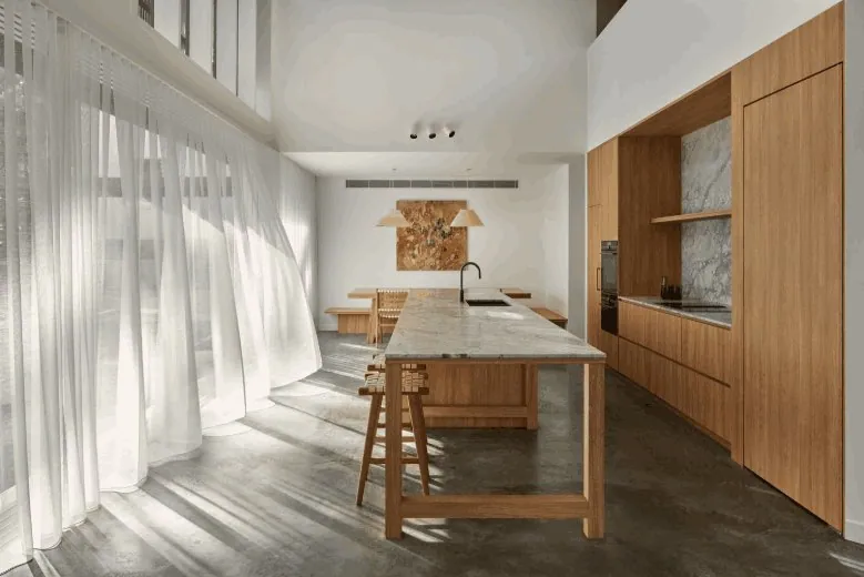 Burnished concrete kitchen floor with a stone island in Brisbane