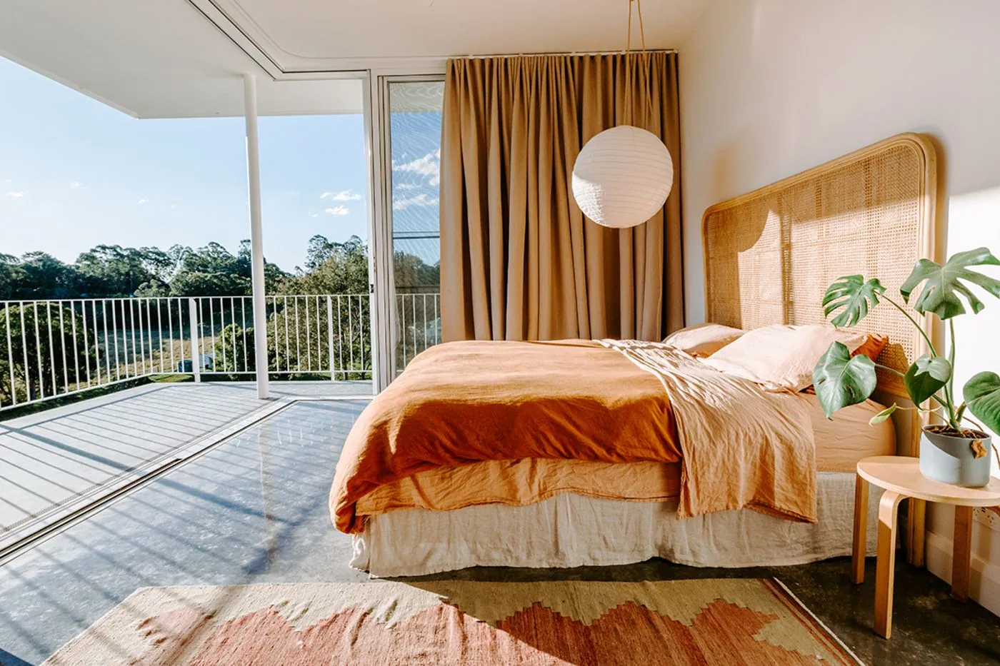 Bedroom with a polished concrete floor opening to a balcony in a Queensland home