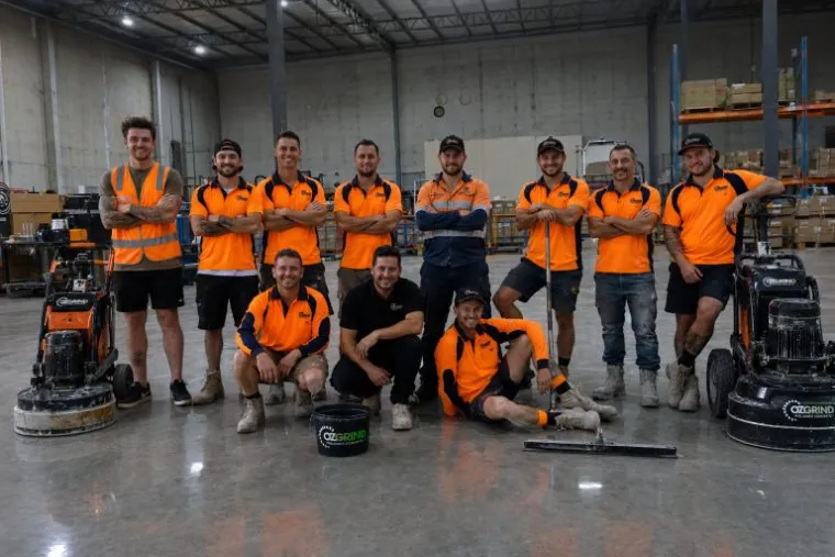 The OzGrind polished concrete team with grinding machines in their Brisbane warehouse