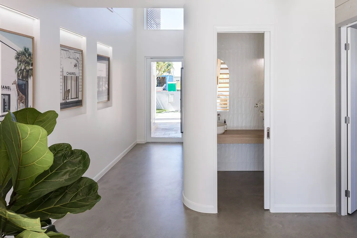 Polished concrete floor through the hallway and powder room of a Monster Homes residence, Brisbane