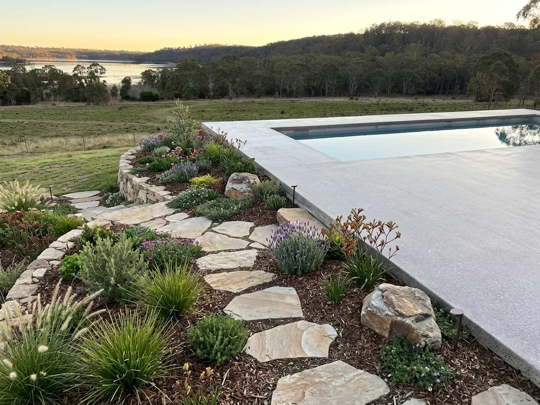 Honed concrete pool surround with rock garden and lake views in Queensland