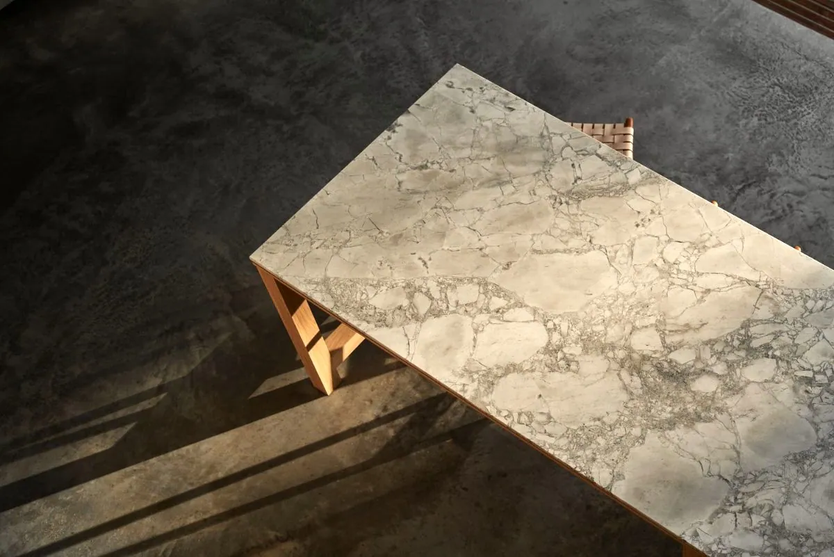 Polished concrete floor with a marble-top table in a styled OzGrind setting