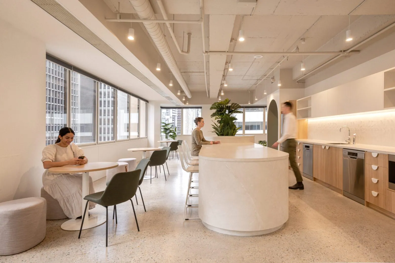 Grind and seal polished concrete floor in a bright office breakout and kitchen with a curved island at the Archway commercial office fit-out, Brisbane