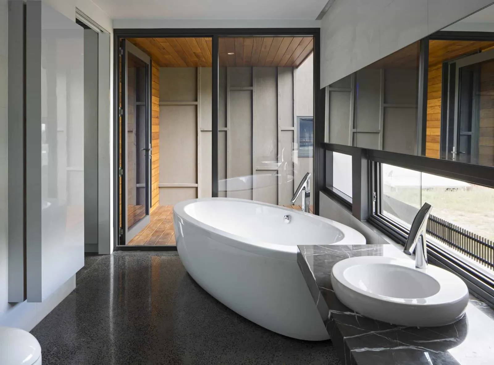 Ensuite with a freestanding bath on a polished concrete floor at the Christian Street home, Clayfield