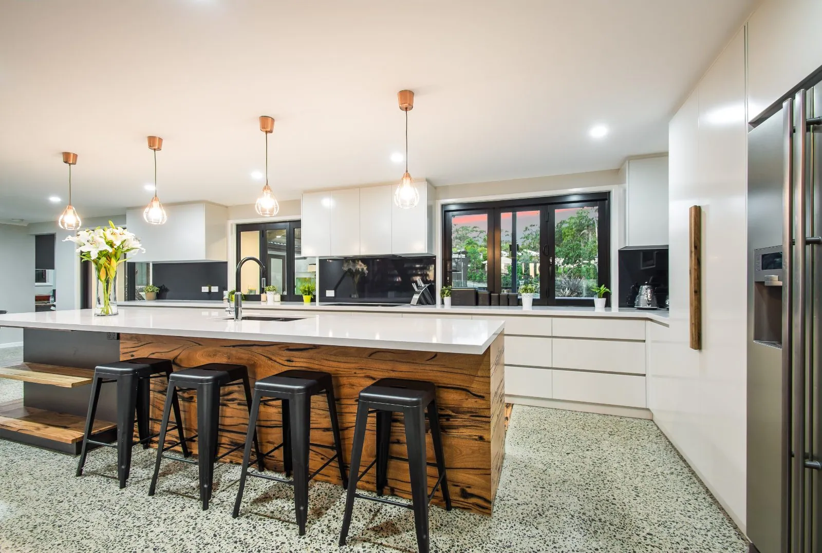 MPC polished concrete floor with a timber island kitchen at dusk, Alexandra Hills Brisbane