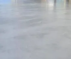 Grey micro cement concrete overlay sealed in a semi gloss finish, showing a soft satin sheen