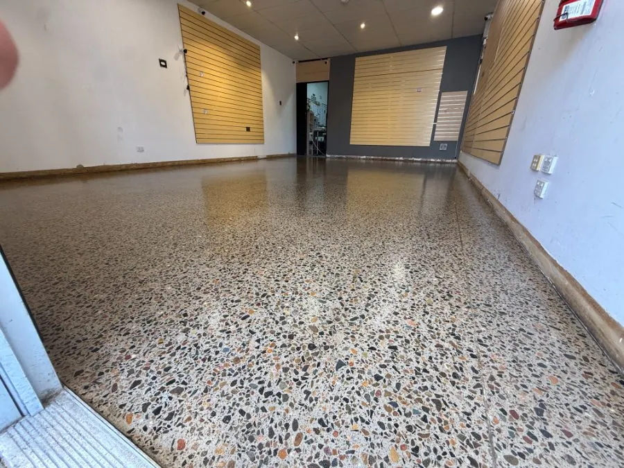 Hybrid polished concrete floor with full-exposure earthy river-pebble aggregate by OzGrind in Brisbane