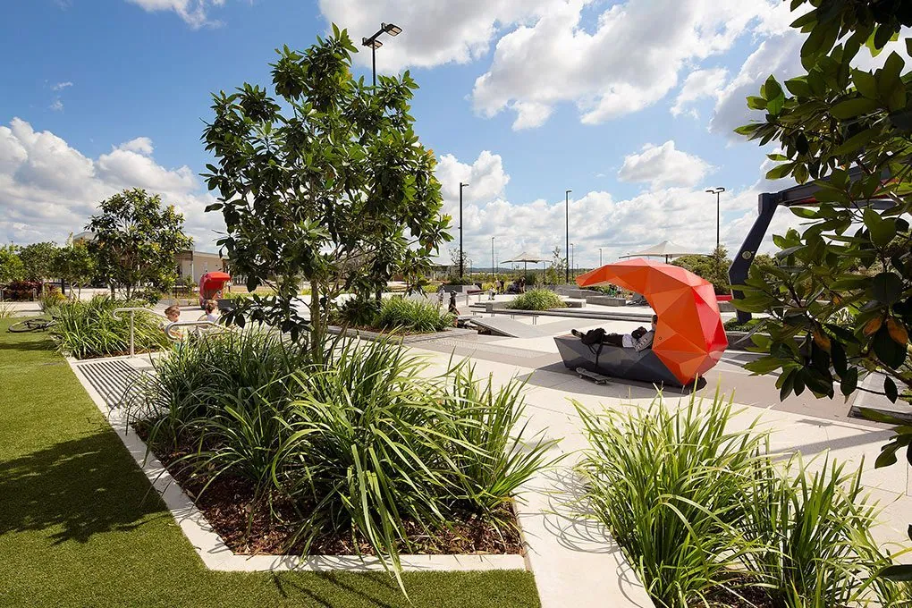 Honed concrete plaza with an orange sculpture seat at Baringa Town Centre, outdoor polished concrete
