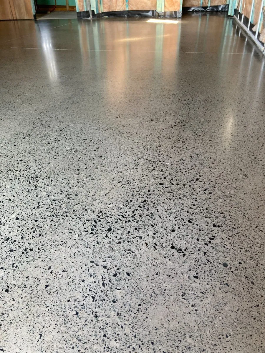 Satin grey full-exposure hybrid polished concrete floor with black aggregate by OzGrind in Brisbane