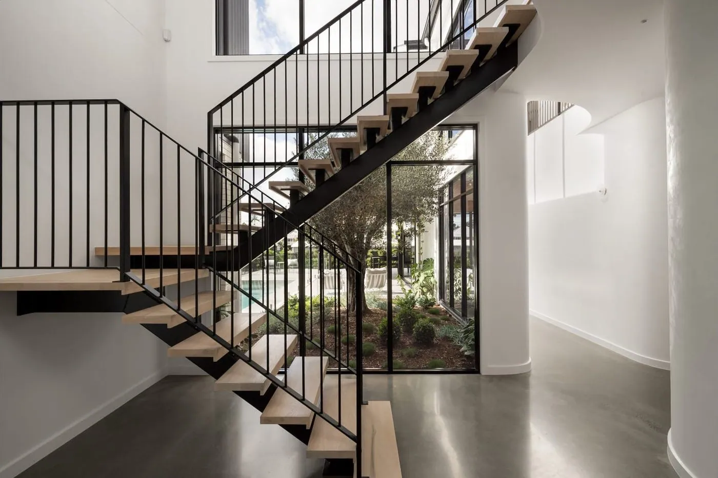 Mechanically polished concrete floor in a light-filled staircase void, nil exposure semi-gloss, Brisbane