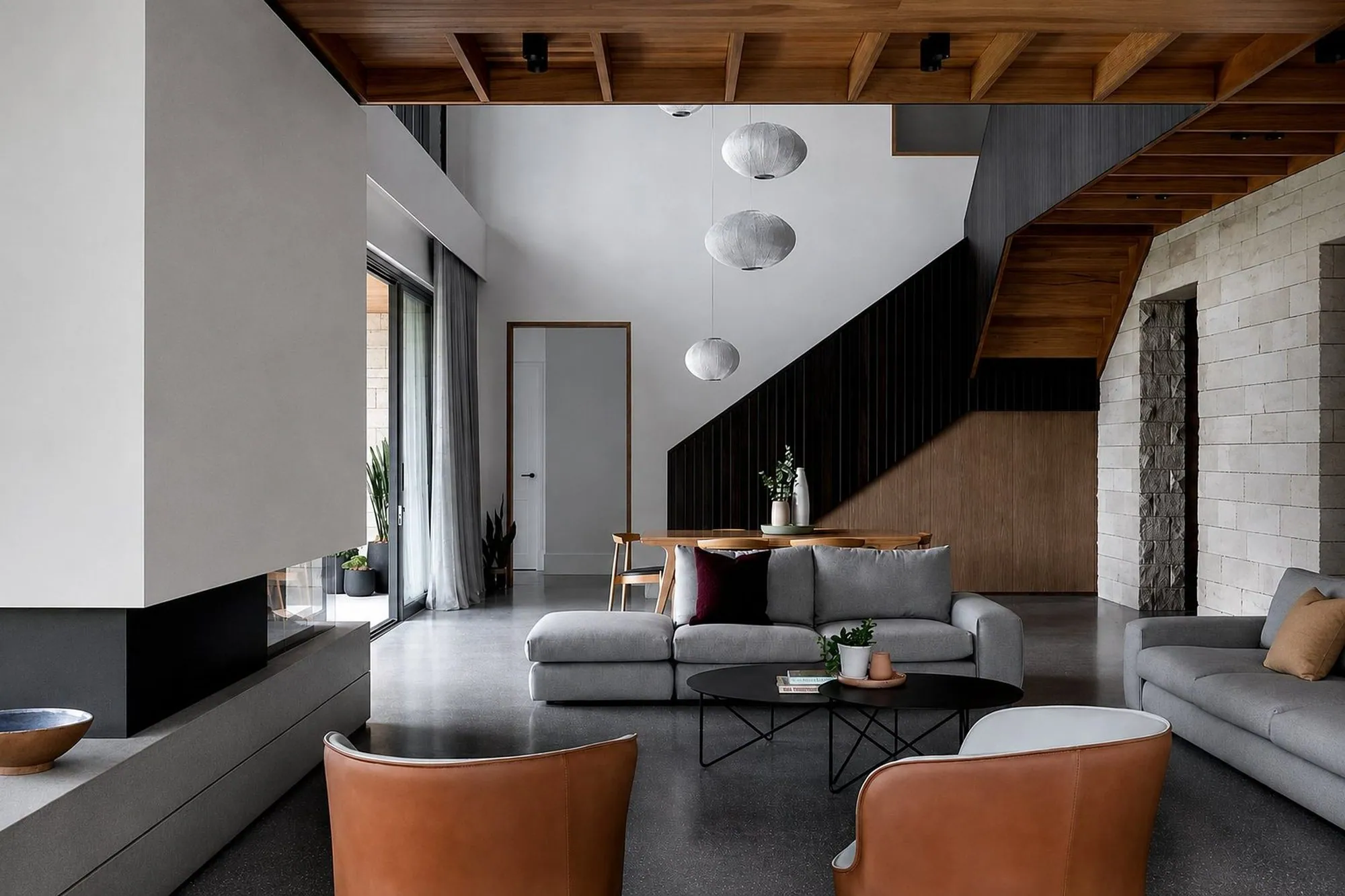 Polished concrete floor in a modern Brisbane living room with timber ceiling and stone feature wall