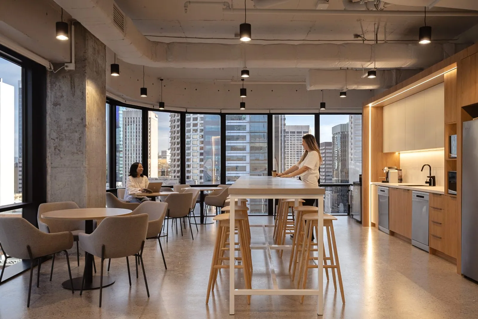 Grind and seal polished concrete floor flowing through an open plan office lounge with city views at the Archway commercial fit-out, Brisbane