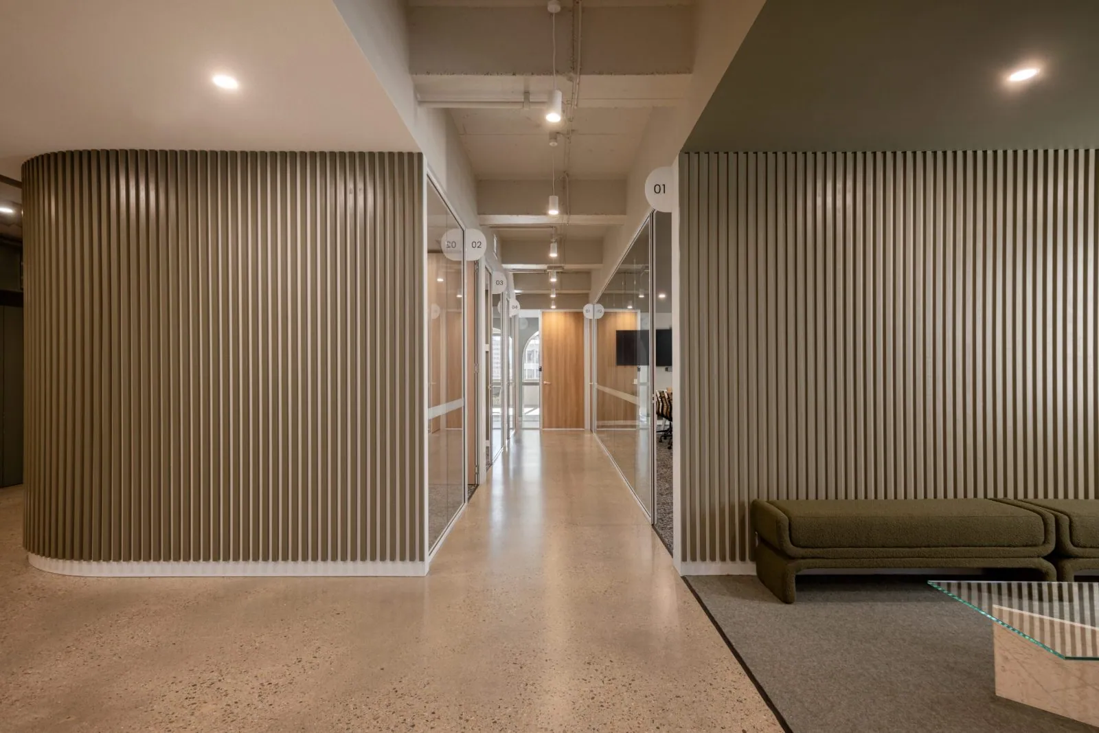 Grind and seal polished concrete floor in a grind and seal polished concrete corridor with a timber batten wall at the Archway commercial office fit-out, Brisbane