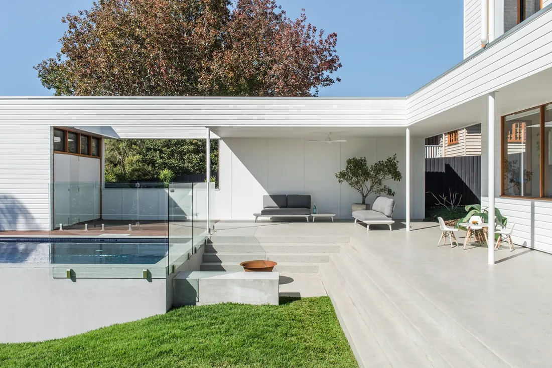 Honed concrete pool surround at a modern white Brisbane home