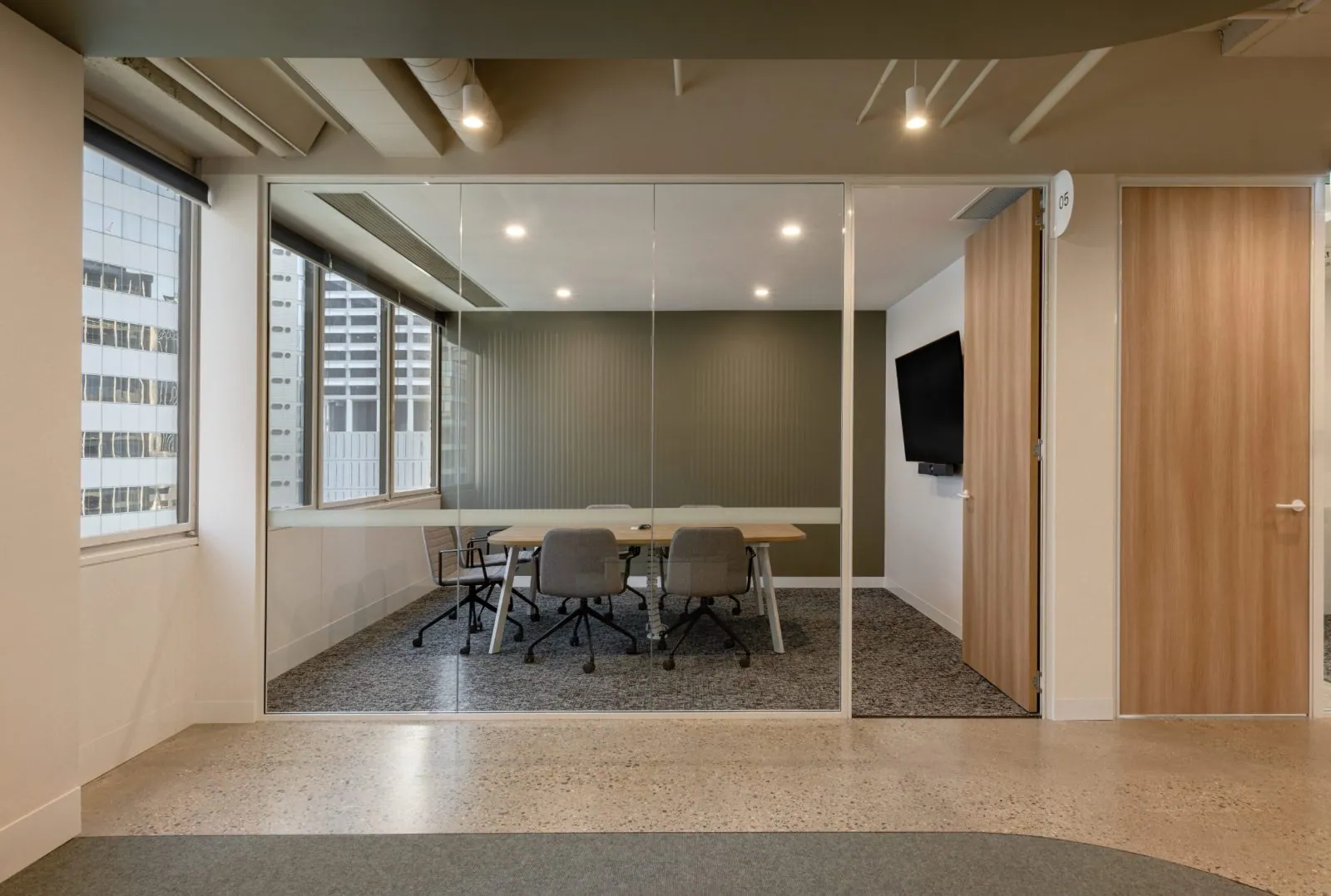 Grind and seal polished concrete floor in a glass meeting room off the polished concrete floor at the Archway commercial office fit-out, Brisbane
