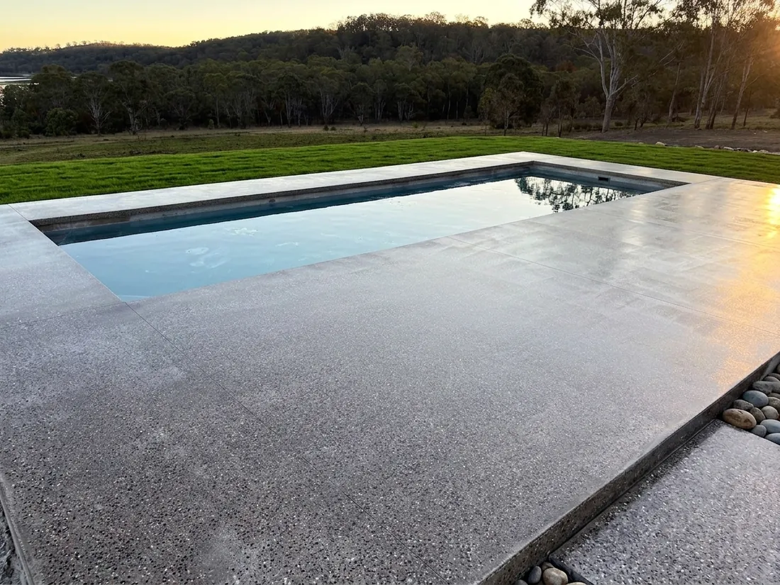 Honed concrete pool surround at sunset on a Queensland property