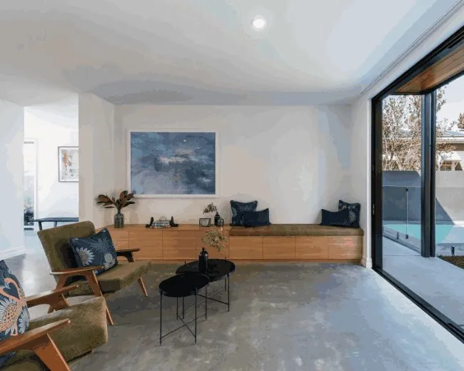 Burnished concrete living room floor opening to a pool in Brisbane