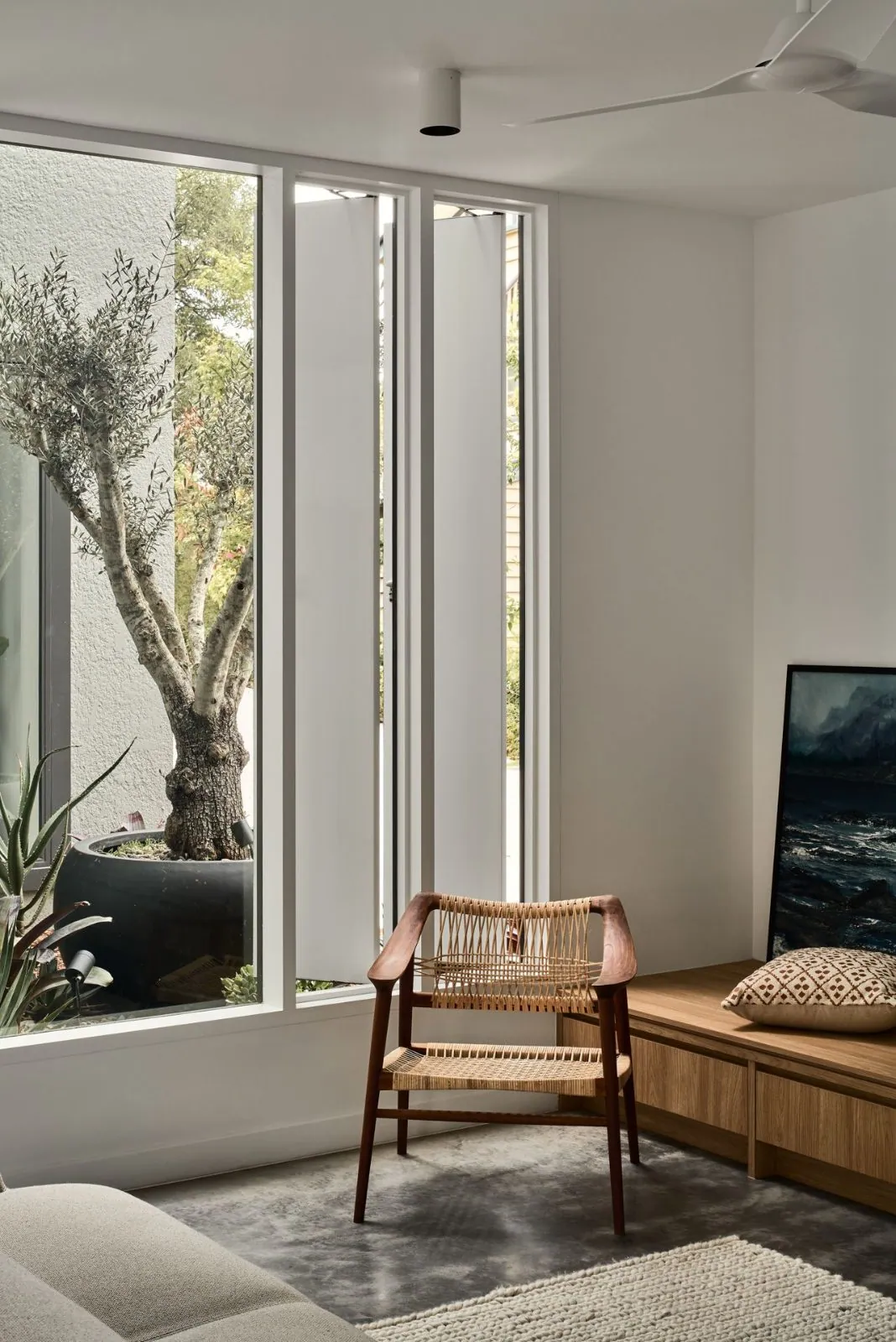 Living room with a timber window seat and a natural polished concrete floor