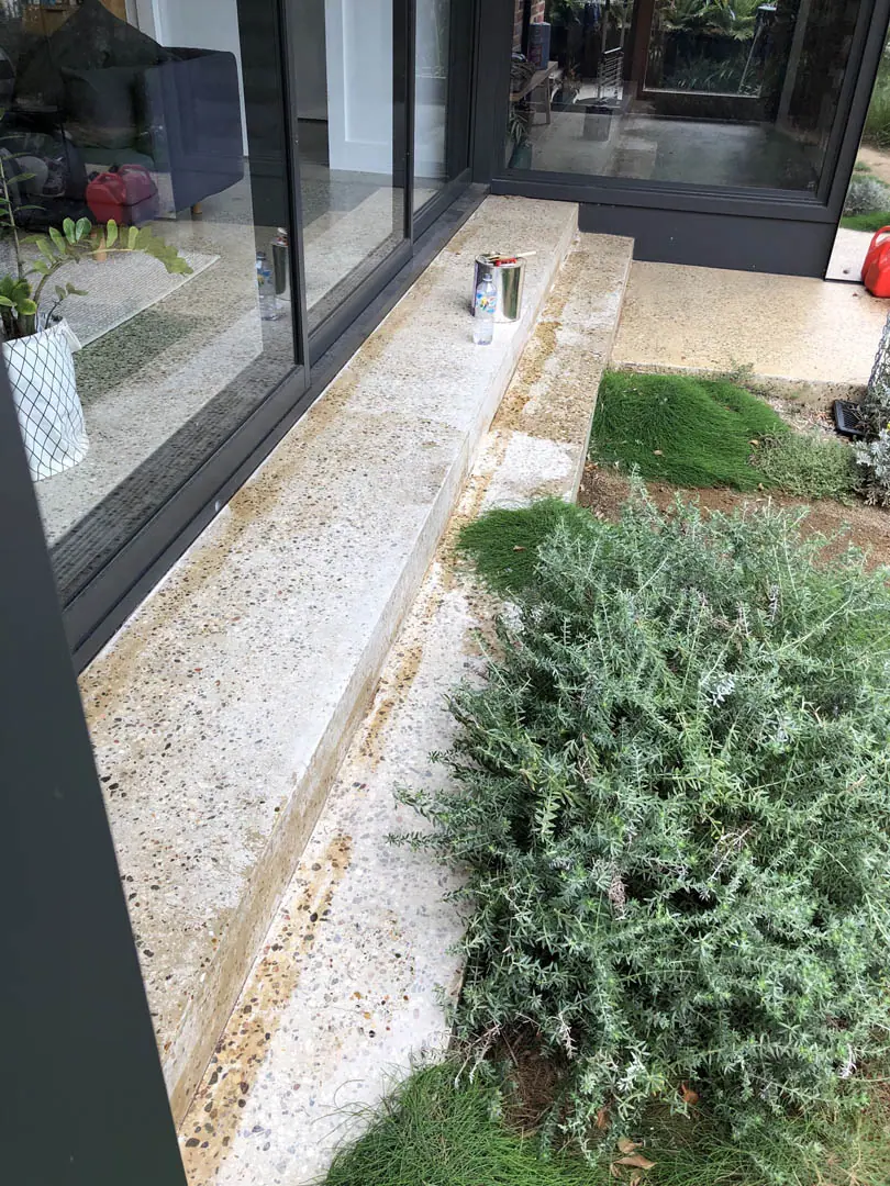 Salty efflorescence blooming through a topical sealer on an outdoor slab