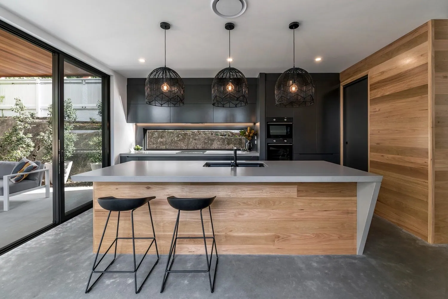 Polished concrete floor in the black and timber kitchen of the Duffy house, as seen on Ready Set Reno