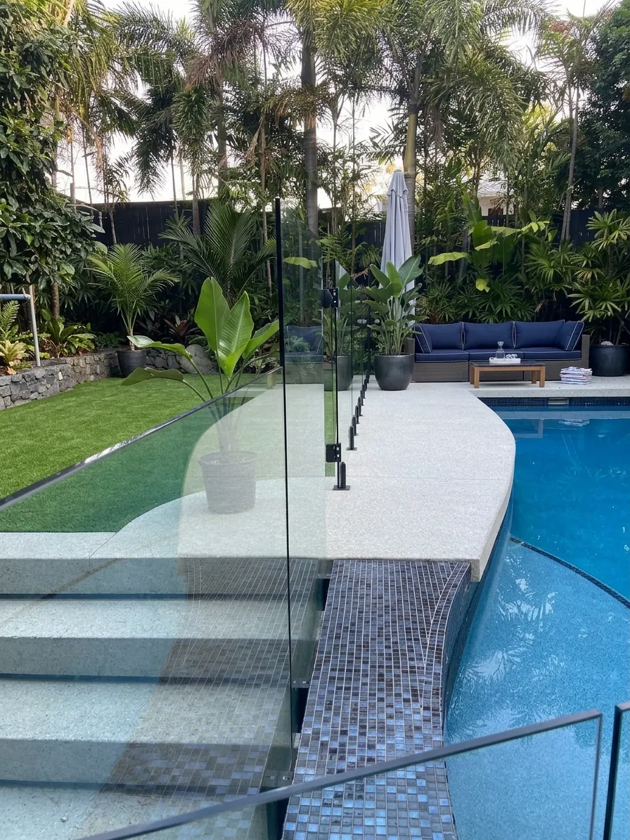 Honed concrete pool surround with glass fencing at a Brisbane home