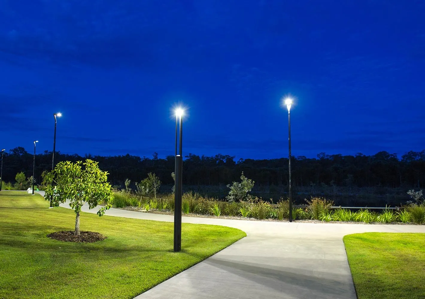 Outdoor honed concrete path and pergola through the Stockland Aura public parkland, Bells Creek