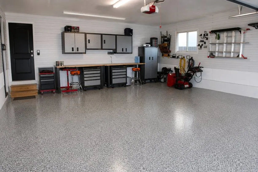 Epoxy flake workshop floor Speckled flake epoxy garage floor in a workshop with cabinets and a workbench