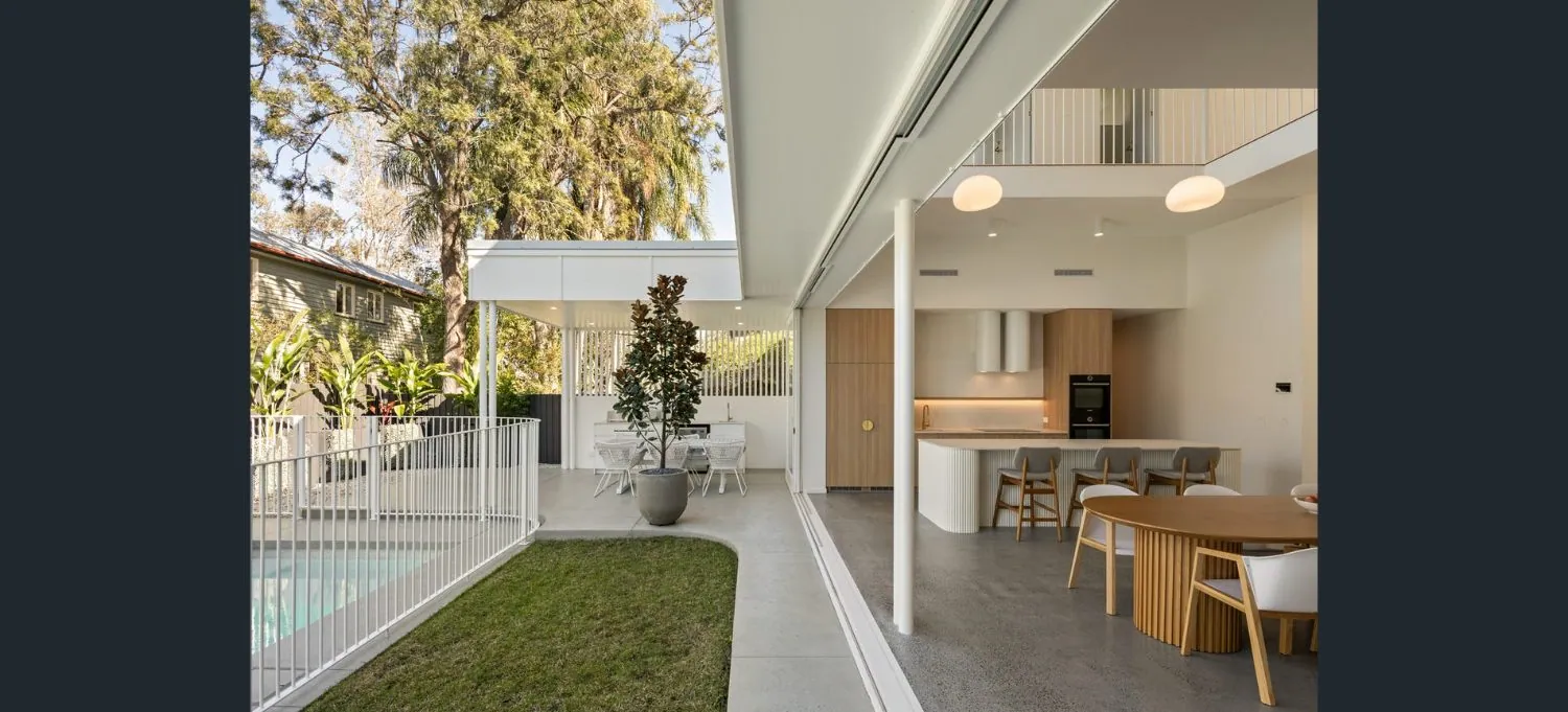 Honed concrete floor flowing from an open-plan kitchen to the pool and lawn at a Brisbane home