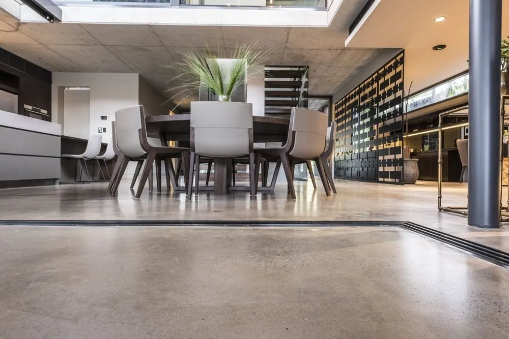 Open-plan dining area with a honed mid-grey polished concrete floor