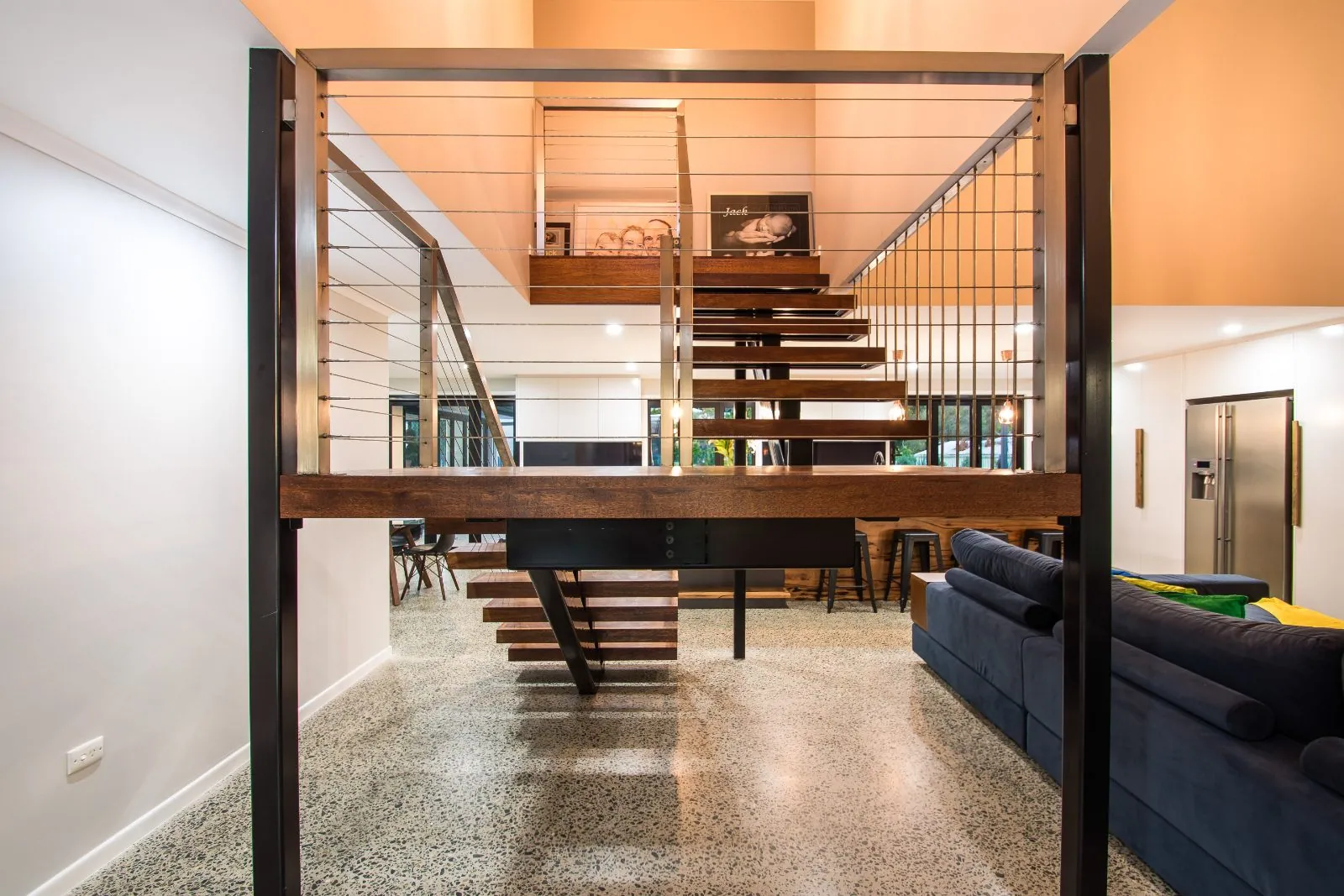 Full exposure polished concrete floor beneath a timber staircase, Alexandra Hills Brisbane