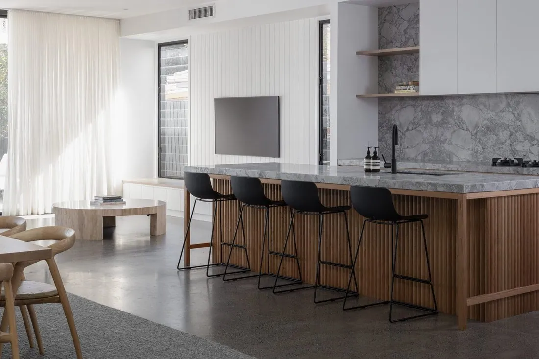 Timber fluted island bench on a semi gloss mechanically polished concrete floor in the Eclat Building kitchen, Hendra