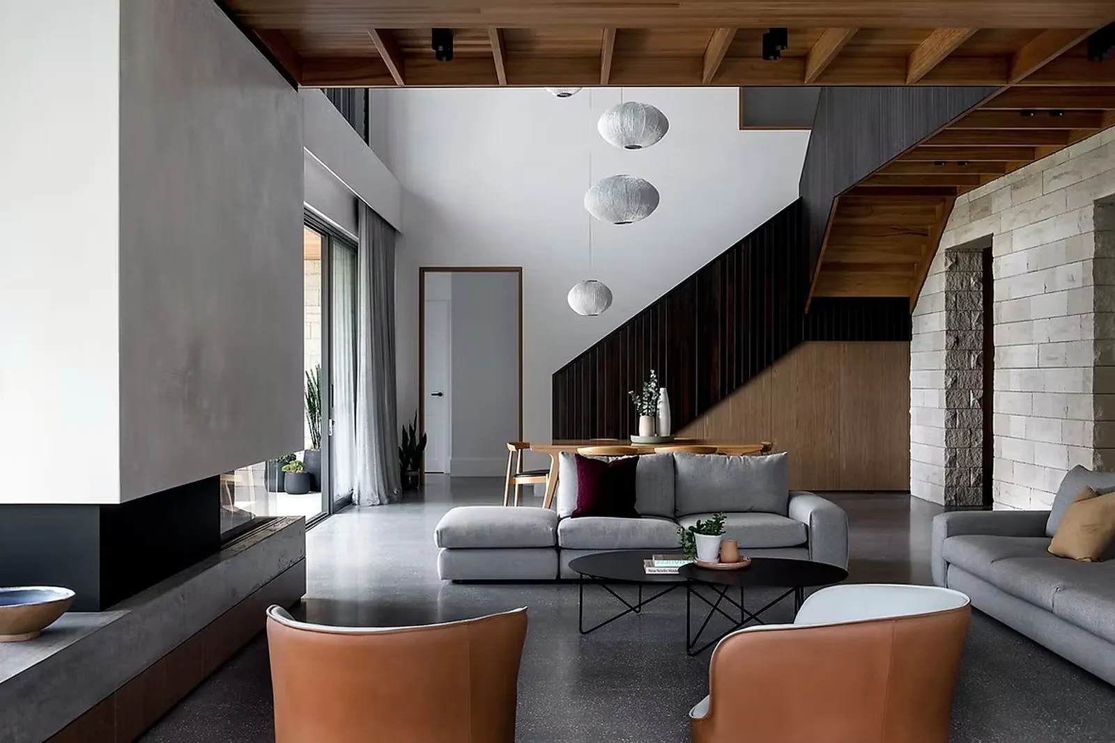 Mechanically polished concrete floor in a Brisbane living room with fireplace and timber stairs