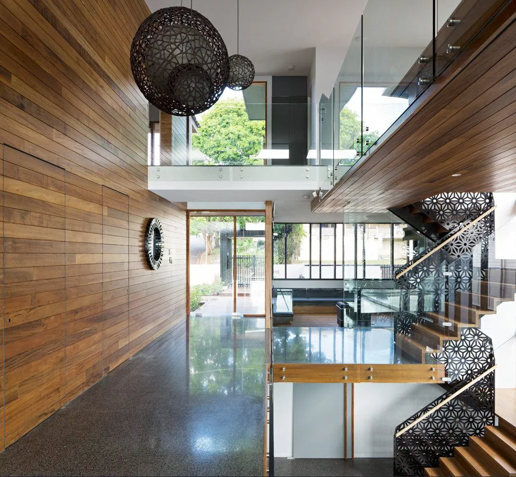 MPC high-gloss polished concrete in a timber-lined entry with glass stair