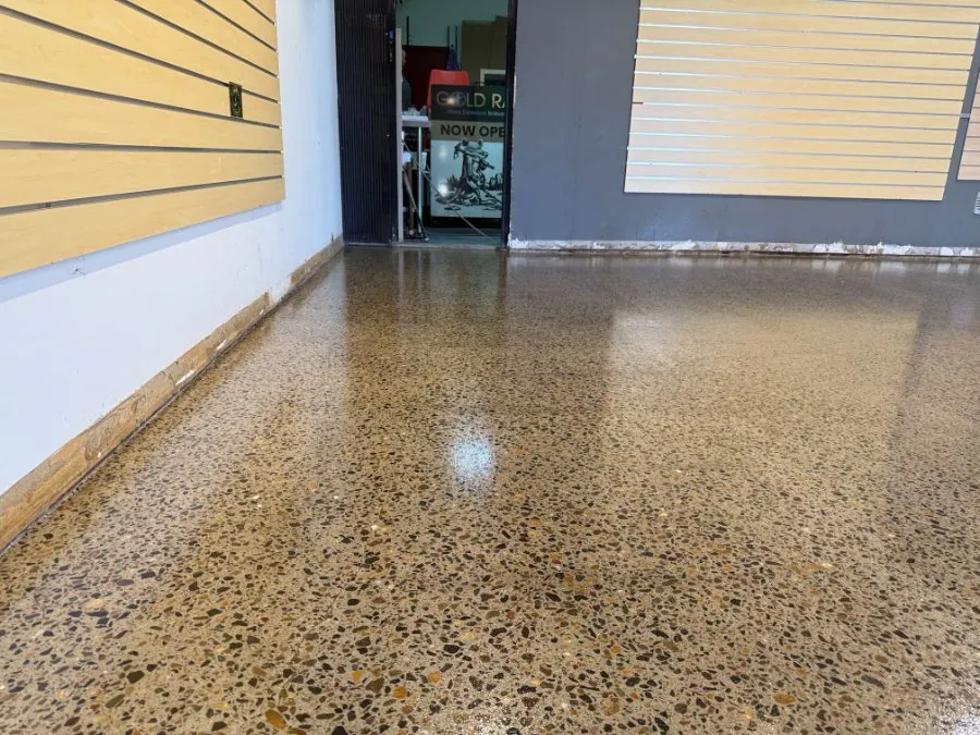 Warm tan river-pebble hybrid polished concrete floor with full aggregate exposure by OzGrind in Brisbane