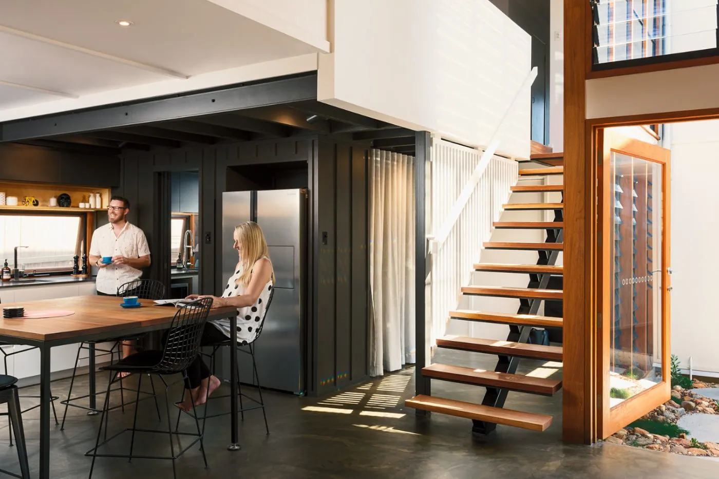 Deep charcoal polished concrete overlay floor in an architectural Brisbane home by OzGrind