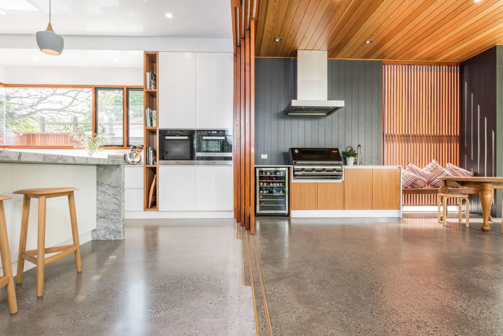 Mechanically polished concrete indoors meeting grind and seal outdoors in one Brisbane home