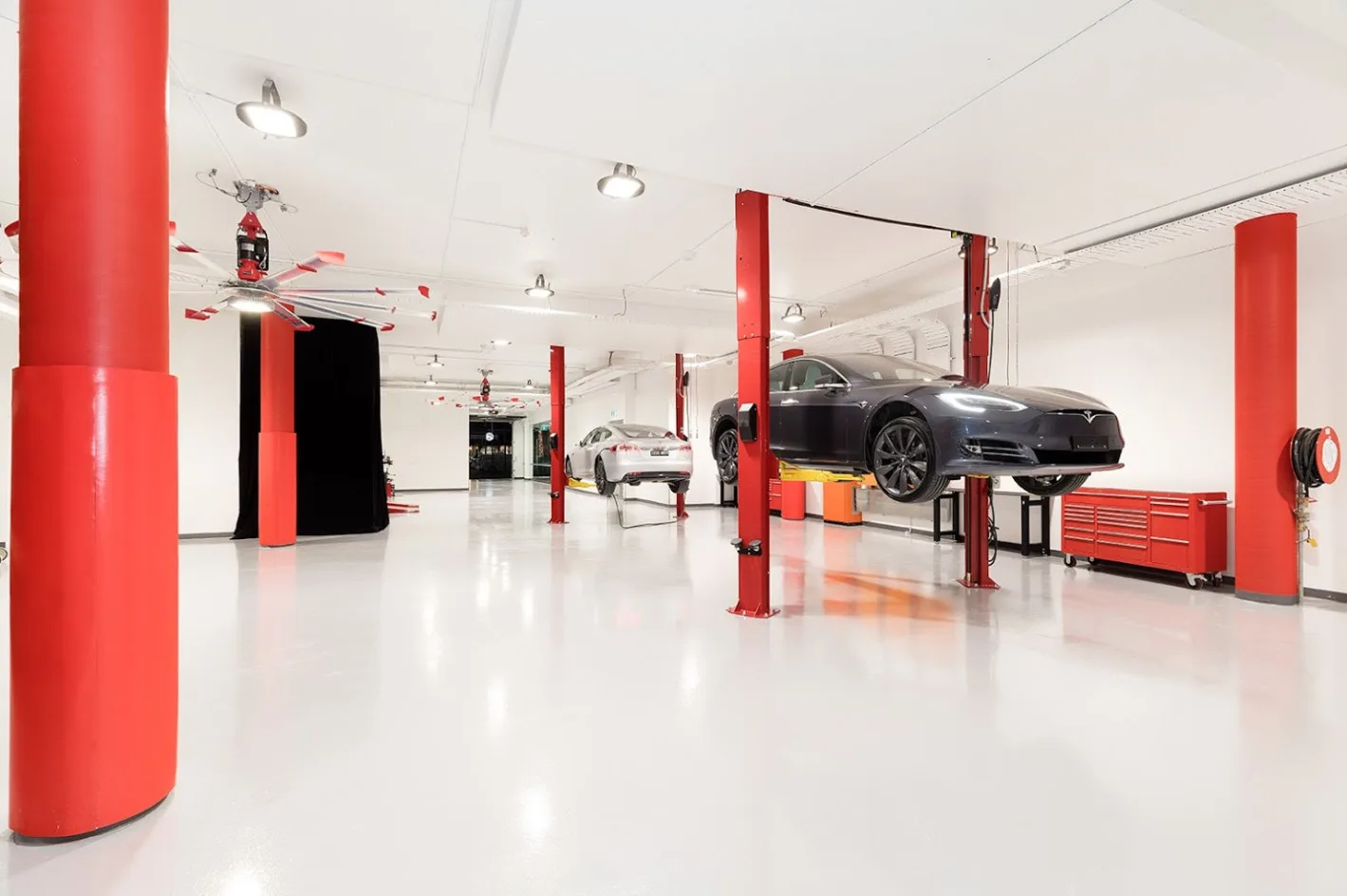White epoxy floor in an automotive workshop with cars on hoists